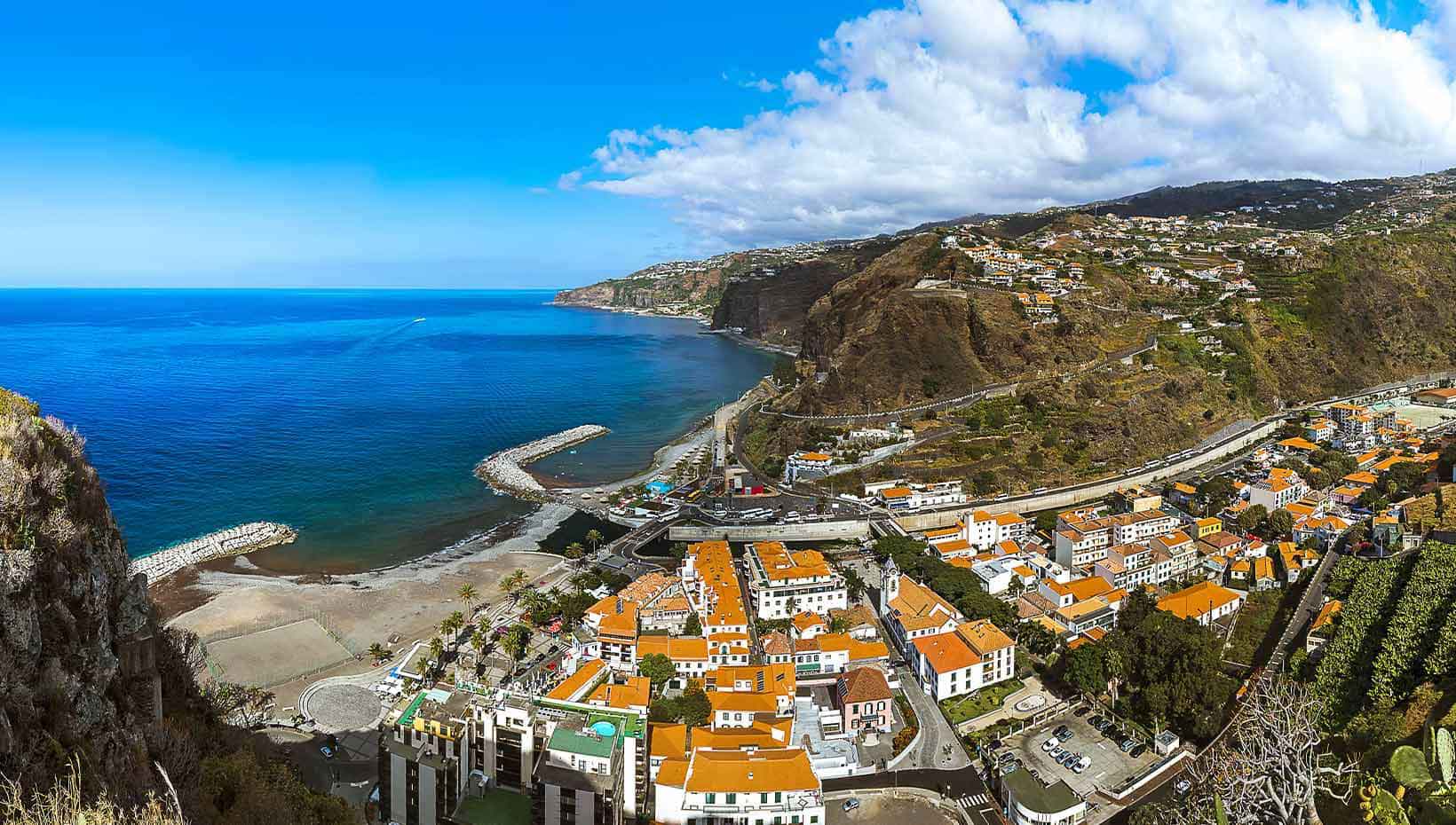 A coastal town with red-roofed buildings and cliffs overlooking the blue ocean | MSC Cruises
