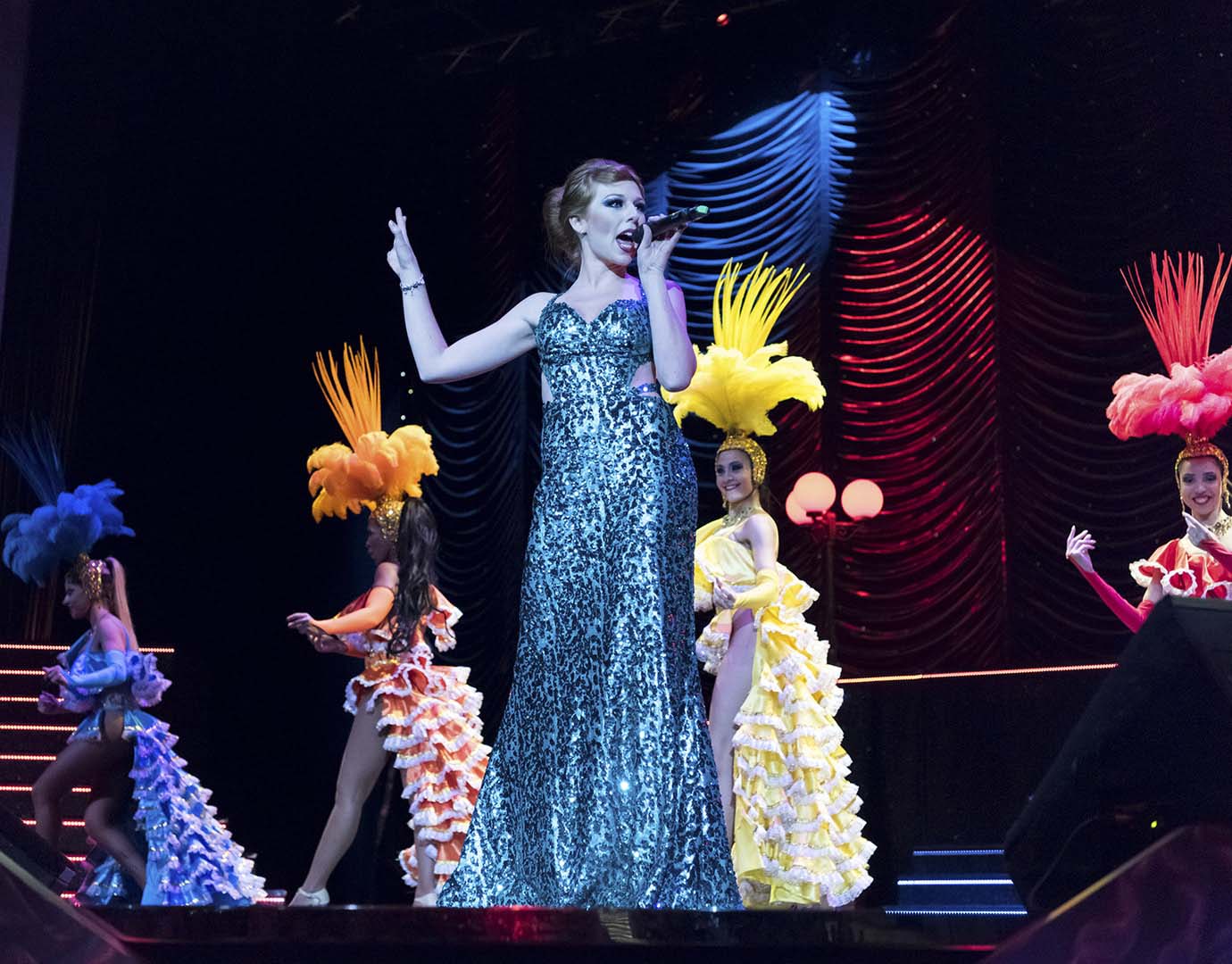 A glamorous stage performance with dancers in colorful costumes and feathered headdresses | MSC Cruises A glamorous stage performance with dancers in colorful costumes and feathered headdresses | MSC Cruises