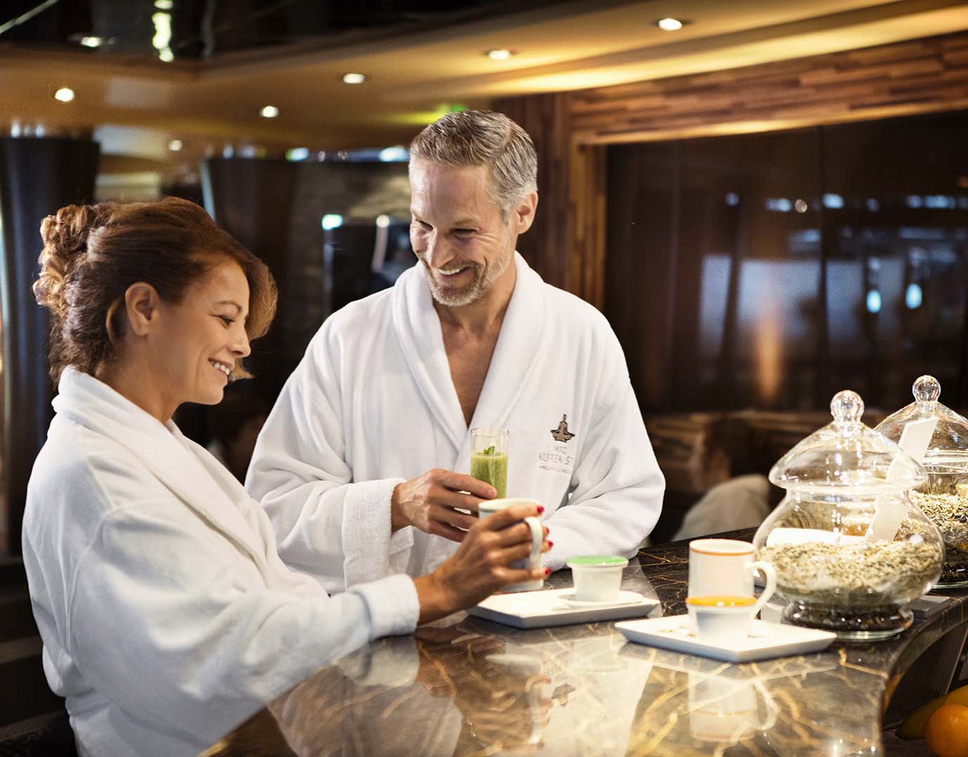 Couple in spa robes enjoying tea and drinks at a luxurious onboard lounge | MSC Cruises Couple in spa robes enjoying tea and drinks at a luxurious onboard lounge | MSC Cruises