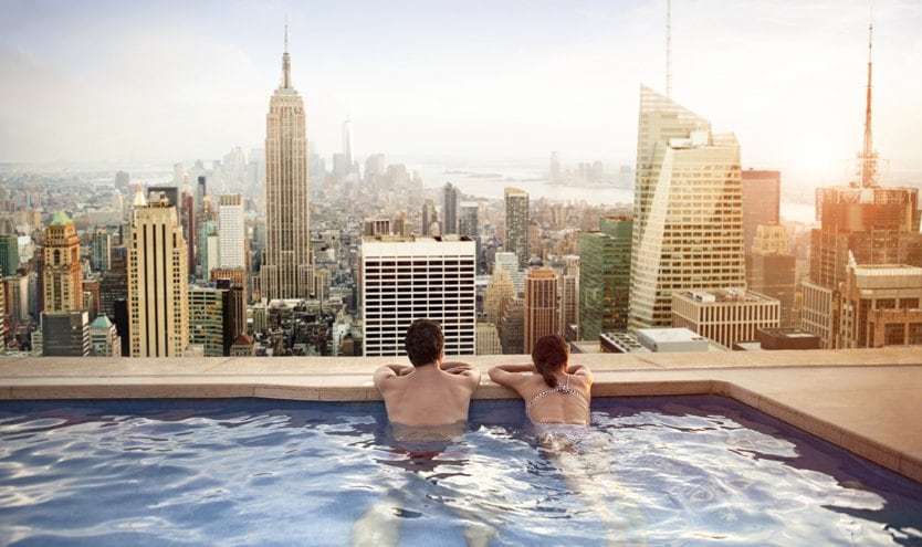 Couple relaxing in an infinity pool overlooking the New York City skyline | MSC Cruises Couple relaxing in an infinity pool overlooking the New York City skyline | MSC Cruises