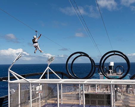 A guest ziplining on an MSC cruise ship with ocean views | MSC Cruises A guest ziplining on an MSC cruise ship with ocean views | MSC Cruises
