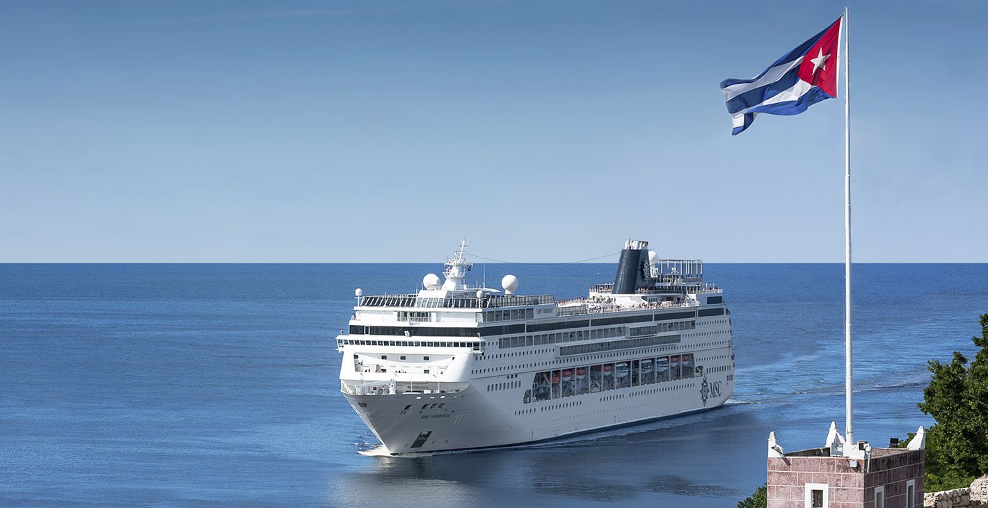 An MSC cruise ship sailing near a Cuban flag on a sunny day | MSC Cruises