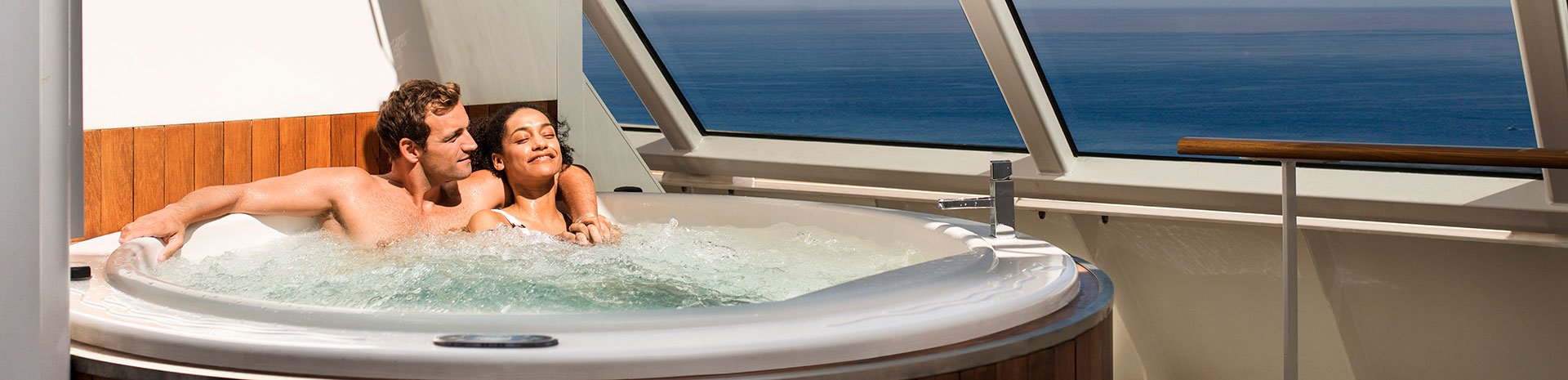 Couple relaxing in a private jacuzzi with ocean views onboard | MSC Cruises