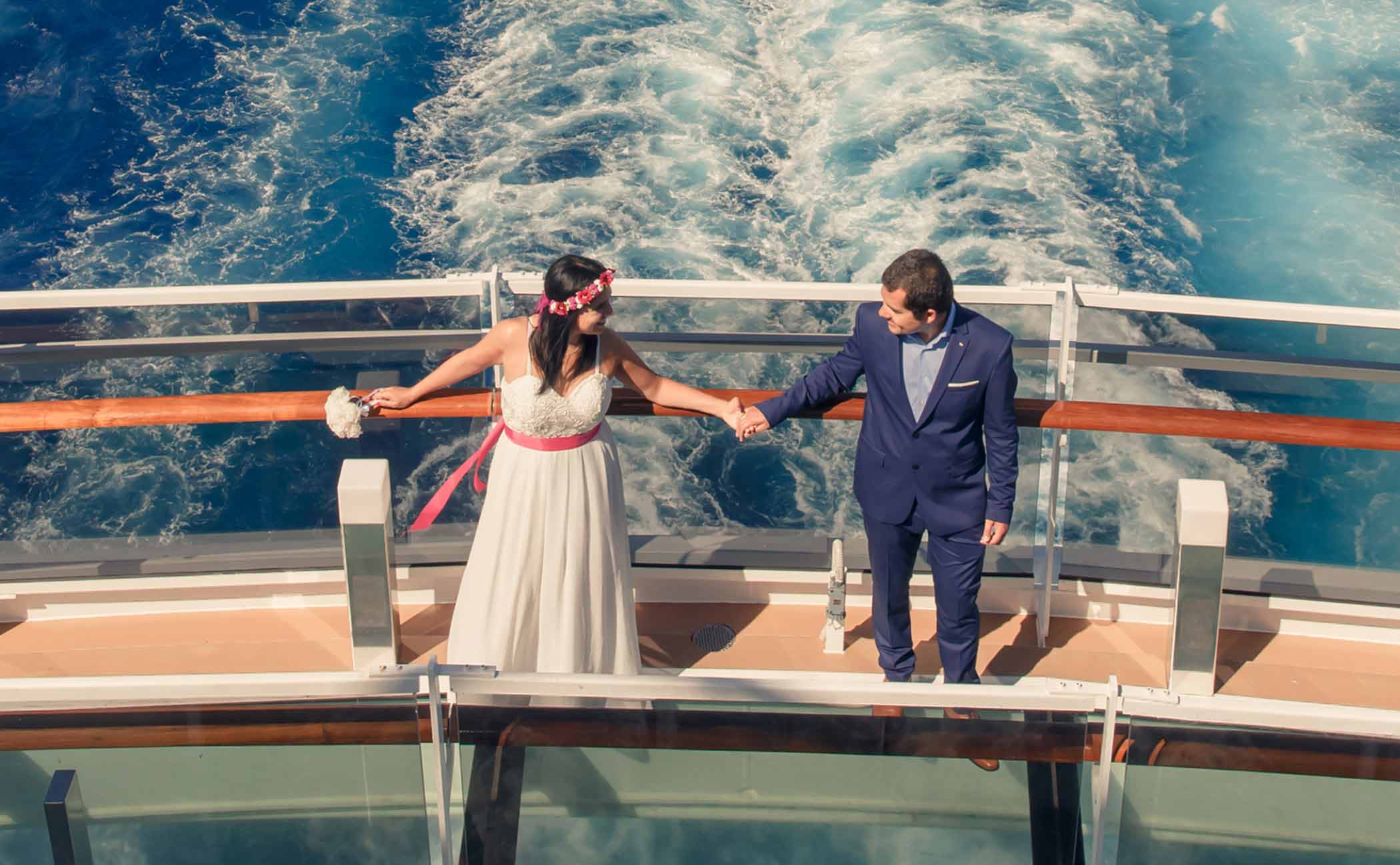 A couple holding hands on a cruise ship deck with ocean waves in the background | MSC Cruises
